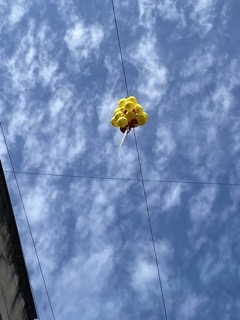 yellow balloons with a smiley face dangling from the wires 